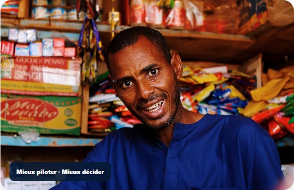 Commerçant dans sa boutique, au milieu de ses marchandises